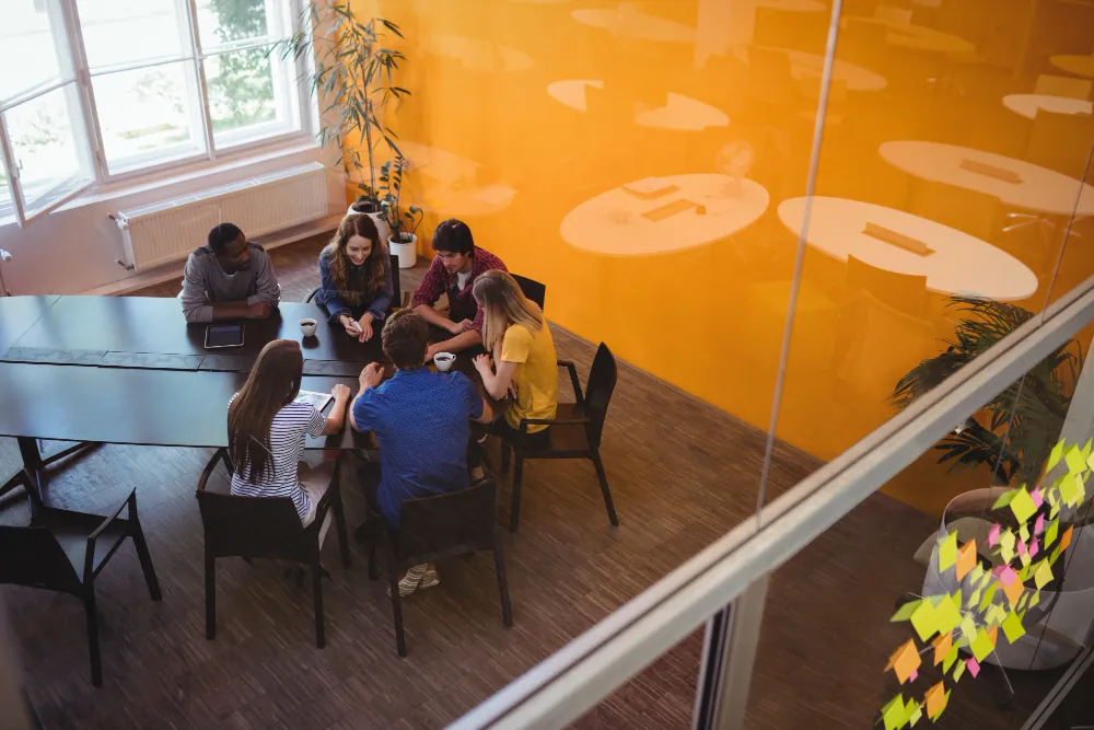 Equipe reunida em mesa de trabalho